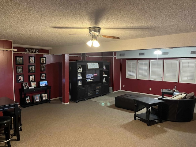 carpeted living room featuring a textured ceiling and ceiling fan