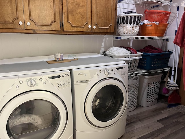 clothes washing area featuring washing machine and dryer, cabinets, and dark hardwood / wood-style floors