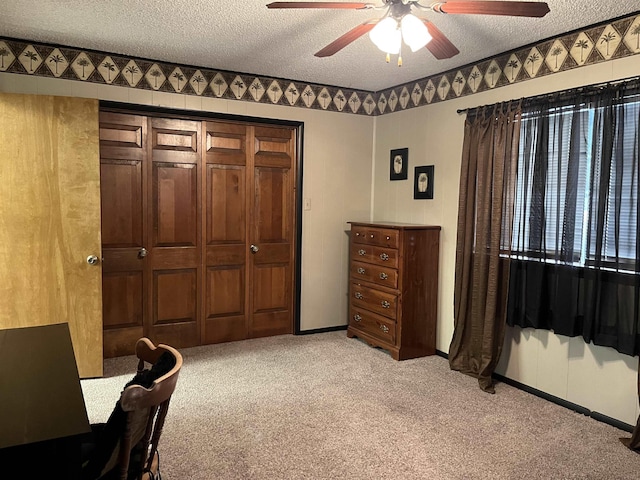 carpeted bedroom featuring a textured ceiling, a closet, and ceiling fan