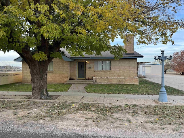 view of front of property featuring a garage, an outdoor structure, and a front yard