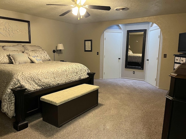 bedroom featuring carpet, a textured ceiling, and ceiling fan