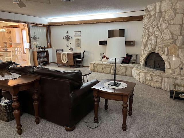 living room featuring ceiling fan, wooden walls, carpet, and a textured ceiling