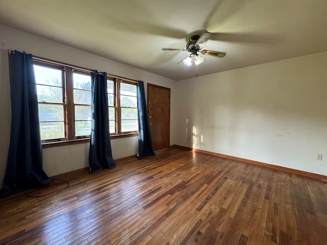 spare room with baseboards, hardwood / wood-style flooring, and a ceiling fan