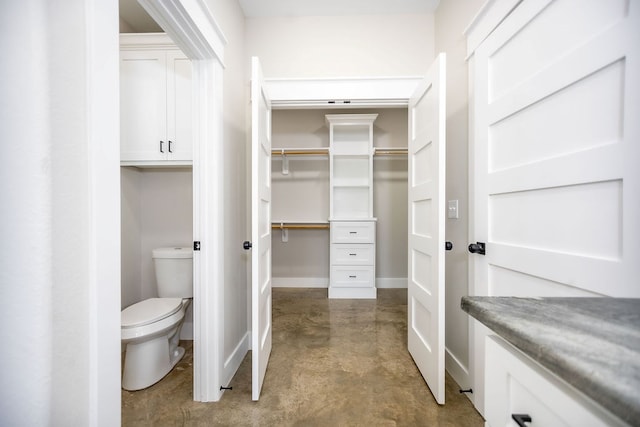 bathroom with toilet and concrete flooring