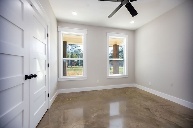 spare room with ceiling fan and concrete flooring