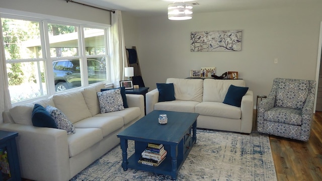 living room with dark hardwood / wood-style flooring and a healthy amount of sunlight