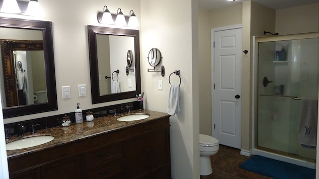 bathroom with tile patterned floors, vanity, toilet, and a shower with shower door