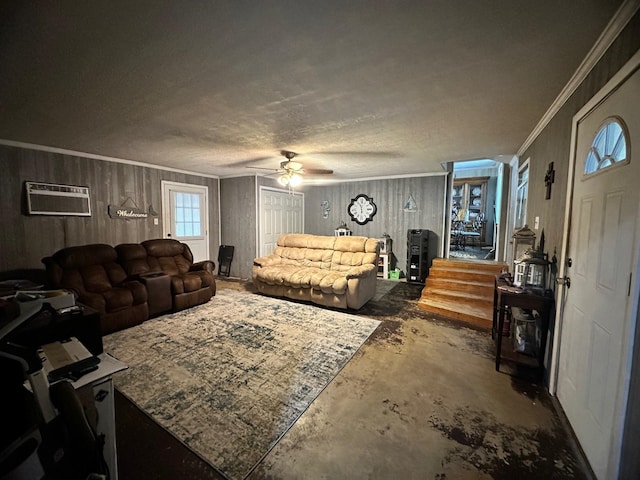 living room featuring a textured ceiling, a wall unit AC, ceiling fan, wooden walls, and crown molding