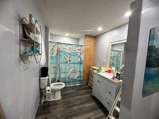 bathroom with wood-type flooring, vanity, a textured ceiling, and toilet