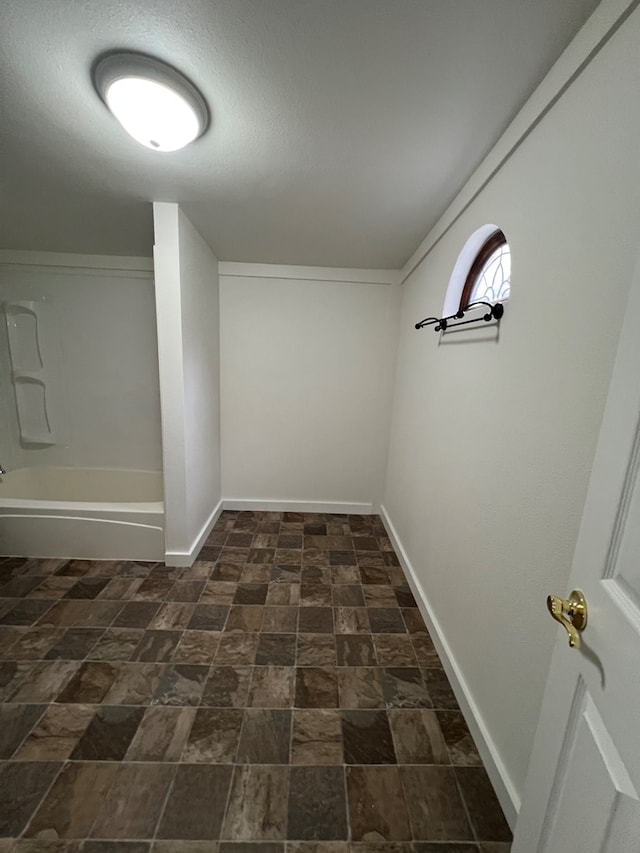 interior space with baseboards and stone finish flooring