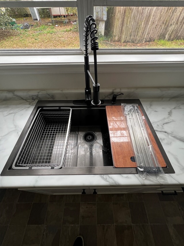 details featuring a sink and stone countertops