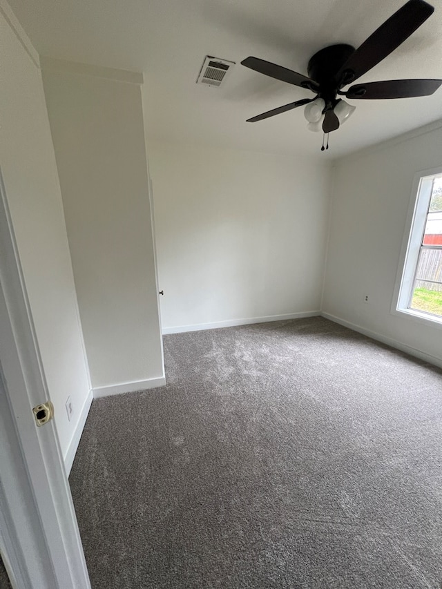 carpeted empty room with visible vents, ceiling fan, and baseboards