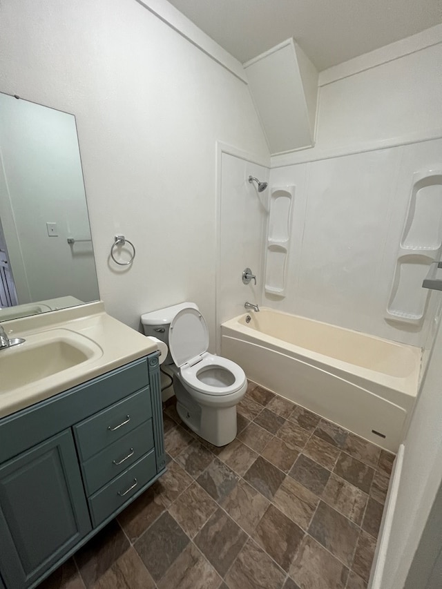 bathroom featuring toilet, shower / washtub combination, vanity, and stone finish floor