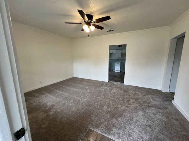 unfurnished room featuring dark colored carpet, visible vents, baseboards, and ornamental molding