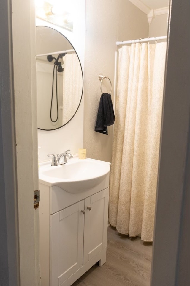 bathroom featuring crown molding, wood finished floors, and vanity