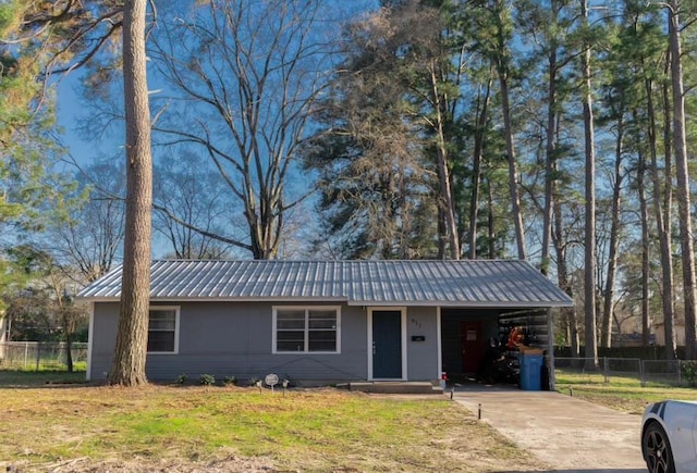 view of front facade featuring an attached carport, concrete driveway, metal roof, and fence