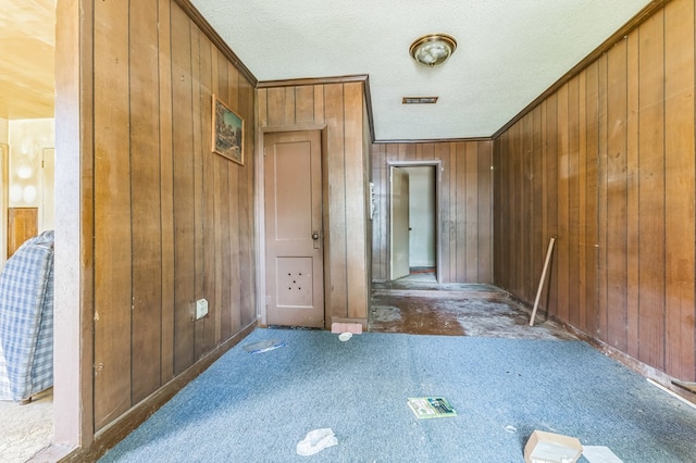 3314 Brook Holw, Nacogdoches, TX 75964 - foyer with wood walls, a textured ceiling, carpet flooring, and ornamental molding