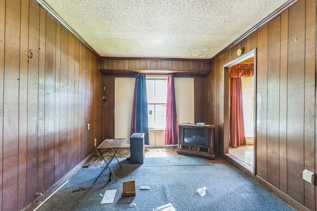 3314 Brook Holw, Nacogdoches, TX 75964 - unfurnished office featuring wood walls, crown molding, a wood stove, carpet floors, and a textured ceiling