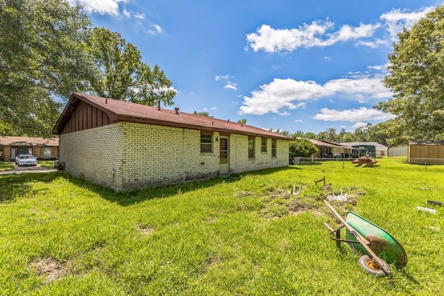 3314 Brook Holw, Nacogdoches, TX 75964 - back of property featuring brick siding, board and batten siding, and a lawn