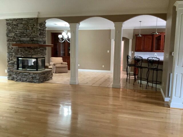 810 Denton Dr, Jasper, TX 75951 - living area featuring ornate columns, light wood finished floors, a stone fireplace, and arched walkways