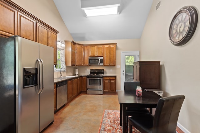 182 Post Oak Ln, Brookeland, TX 75931 - kitchen with appliances with stainless steel finishes, a sink, lofted ceiling, brown cabinets, and concrete floors