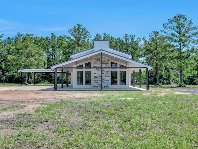 10165 US Highway 287, Corrigan, TX 75939 - rear view of house with a yard, french doors, stone siding, and a carport