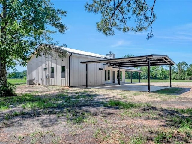 10165 US Highway 287, Corrigan, TX 75939 - rear view of property with an attached carport, a patio, a chimney, and board and batten siding