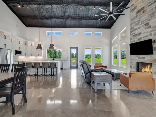 10165 US Highway 287, Corrigan, TX 75939 - living room with a towering ceiling, a ceiling fan, a fireplace, and finished concrete floors
