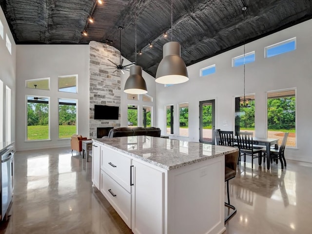 10165 US Highway 287, Corrigan, TX 75939 - kitchen featuring a towering ceiling, track lighting, a center island, white cabinets, and a ceiling fan