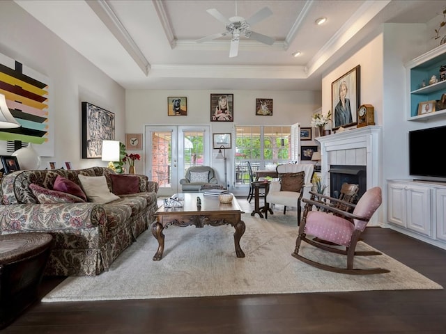 325 Evans Gann Rd, Lufkin, TX 75904 - living room featuring ceiling fan, dark wood-style flooring, crown molding, a tiled fireplace, and a tray ceiling