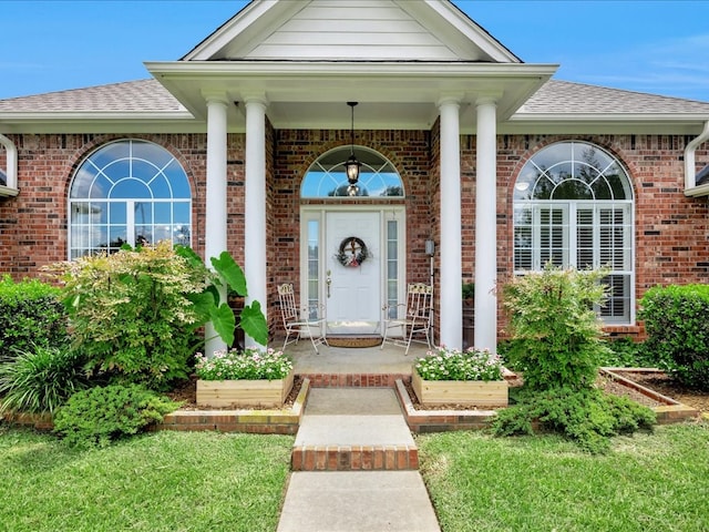 325 Evans Gann Rd, Lufkin, TX 75904 - doorway to property featuring brick siding, a shingled roof, and covered porch
