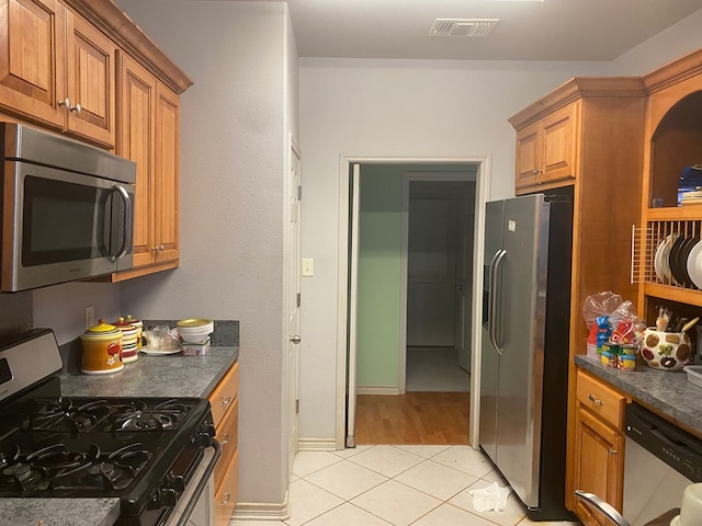 kitchen with light tile patterned floors and appliances with stainless steel finishes