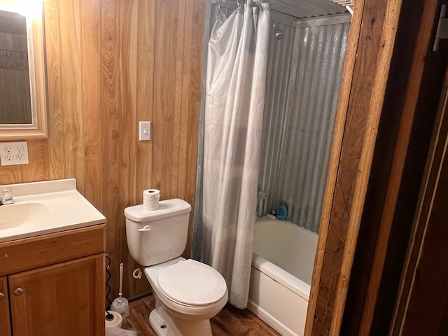 full bathroom featuring wood walls, vanity, shower / bath combination with curtain, and toilet