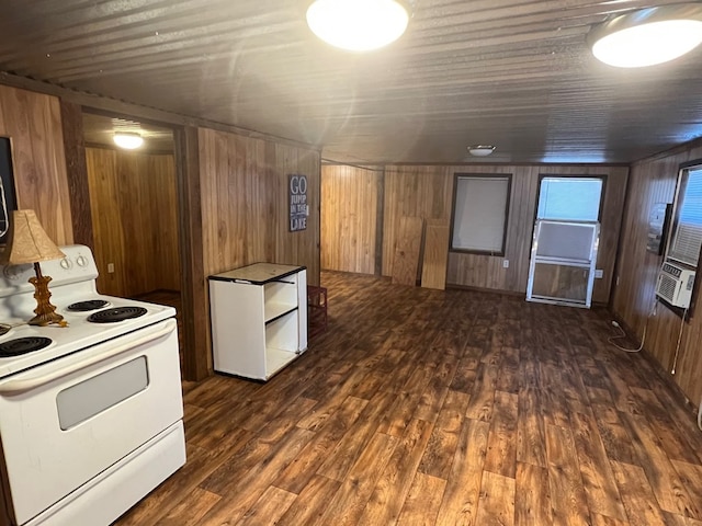 kitchen featuring dark wood-type flooring, wooden walls, and white range with electric cooktop