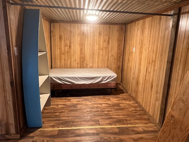 unfurnished bedroom with wood ceiling, wooden walls, and dark hardwood / wood-style floors