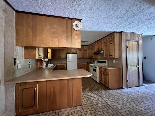 kitchen with kitchen peninsula, a textured ceiling, white appliances, and tile patterned flooring