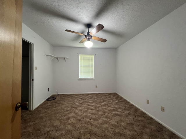 unfurnished bedroom featuring ceiling fan, a textured ceiling, and dark colored carpet