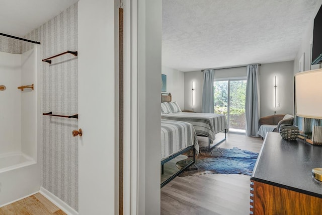 bedroom featuring light wood-type flooring and a textured ceiling