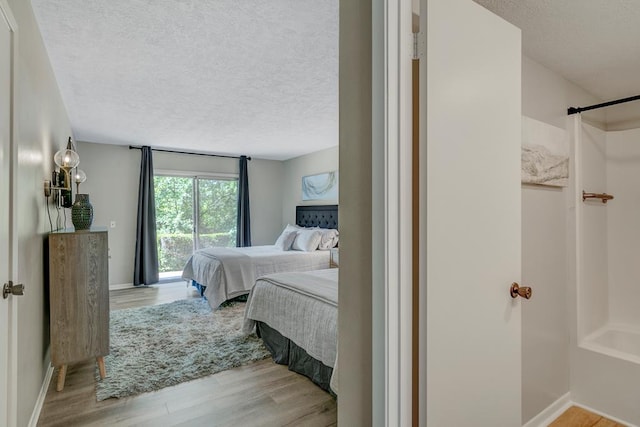 bedroom featuring a textured ceiling and light hardwood / wood-style flooring