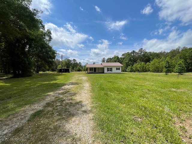 1515 County Road 826, Buna, TX 77612 - ranch-style house featuring a front yard, driveway, and a view of countryside
