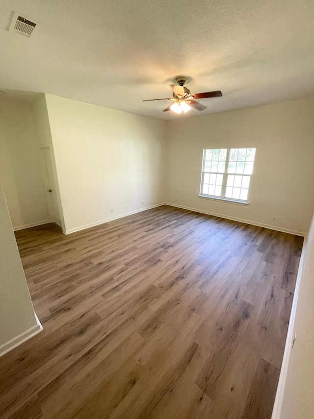 1515 County Road 826, Buna, TX 77612 - unfurnished room featuring wood finished floors, ceiling fan, baseboards, and a textured ceiling