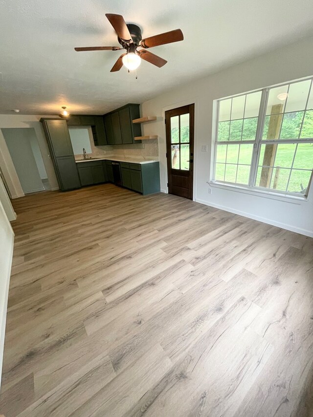 1515 County Road 826, Buna, TX 77612 - unfurnished living room with light wood-type flooring, ceiling fan, baseboards, and a sink