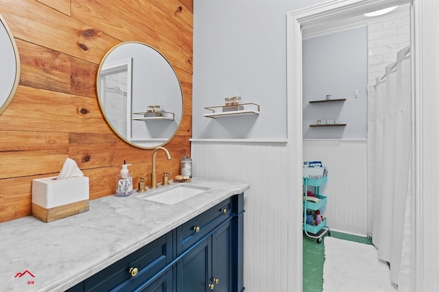 full bath with wood walls, vanity, and wainscoting