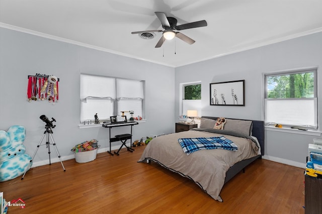 bedroom featuring baseboards, wood finished floors, ornamental molding, and ceiling fan