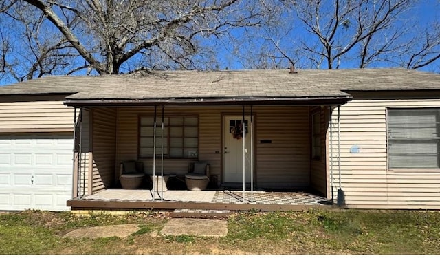 property entrance with a garage and roof with shingles