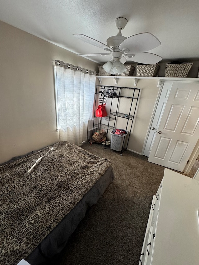 carpeted bedroom with ceiling fan and a textured ceiling