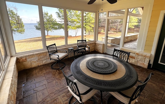 sunroom with a water view, ceiling fan, and a wealth of natural light