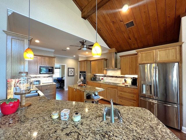 kitchen featuring hanging light fixtures, a kitchen island, wall chimney exhaust hood, and appliances with stainless steel finishes