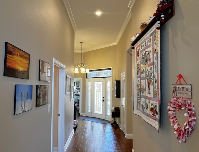 hallway featuring crown molding, dark hardwood / wood-style flooring, and an inviting chandelier