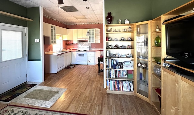 kitchen with white cabinetry, sink, hardwood / wood-style flooring, ceiling fan, and white appliances